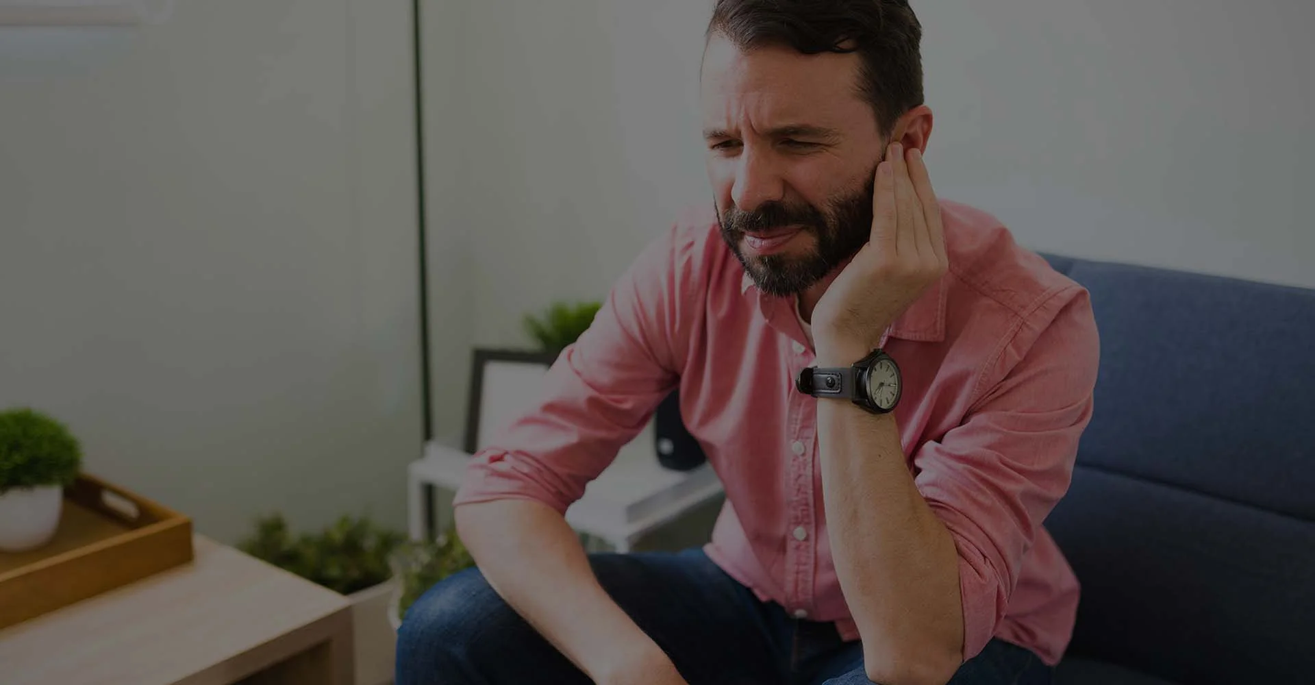 A man covering his ear while in pain