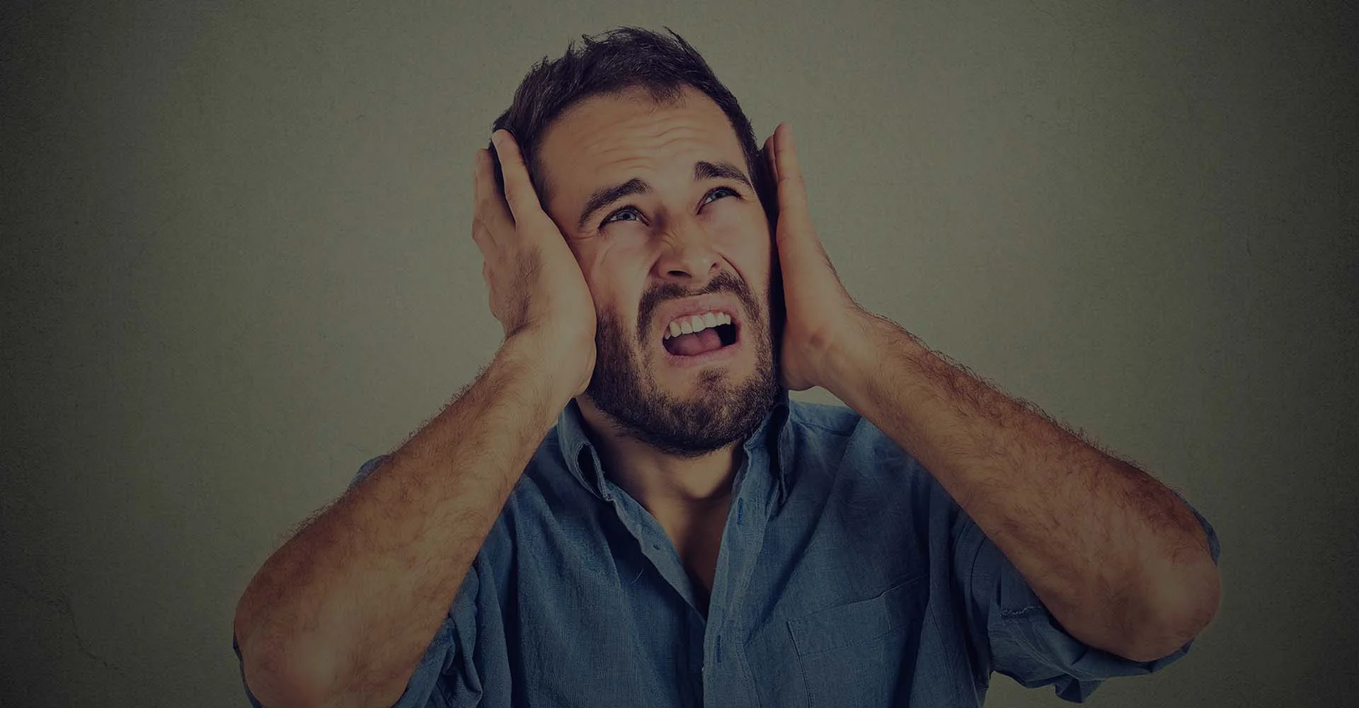Man in pain covering his ears