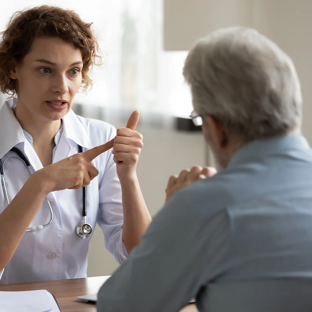 Doctor speaking with a patient at a desk.