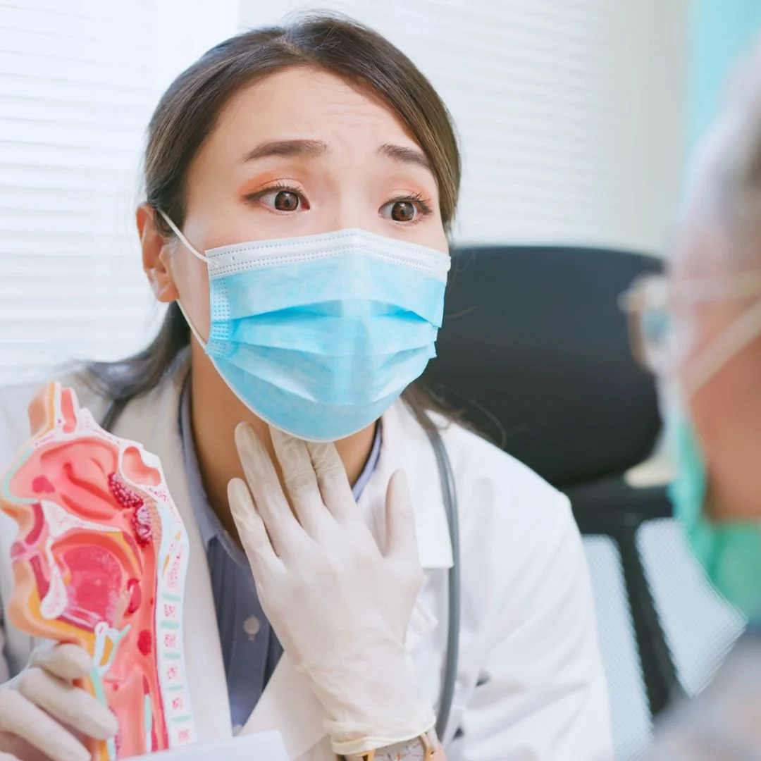 ENT showing throat model to patient