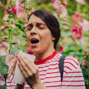 woman sneezing because of seasonal allergies