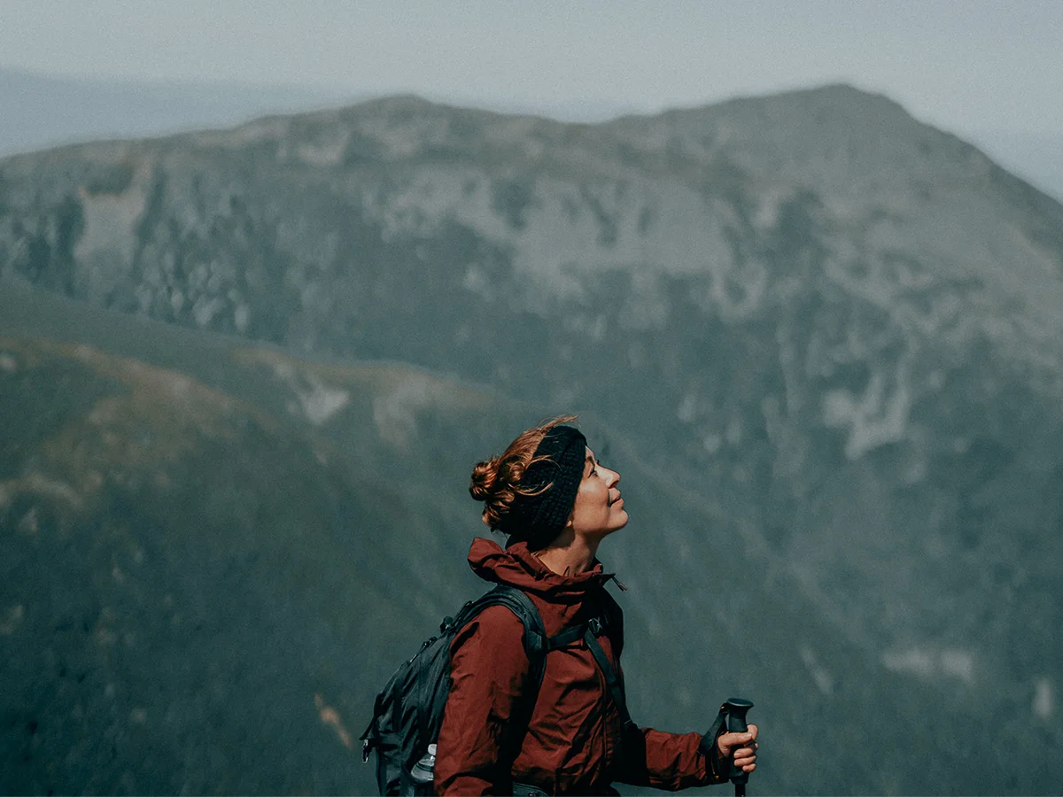 Woman breathing deep on a hike in the mountains