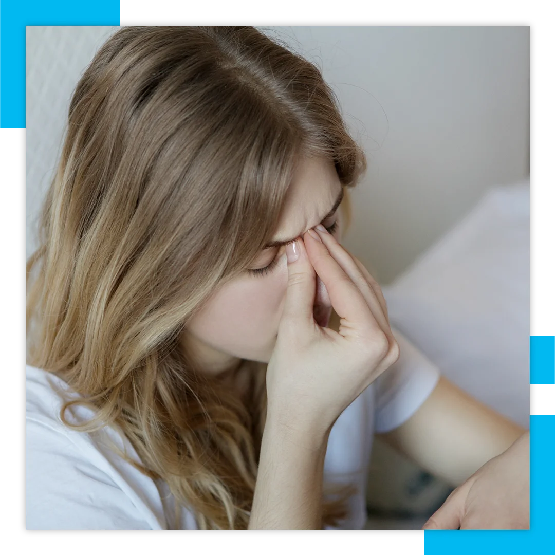 woman pinching bridge of nose